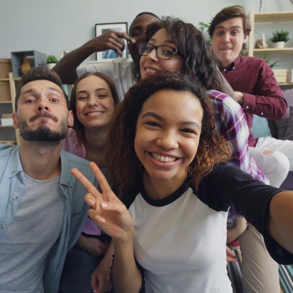 Diverse group of people smiling and looking relaxed in a bright studio.